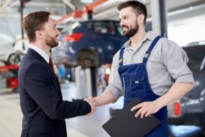 Mechanic Shaking Hands with Businessman